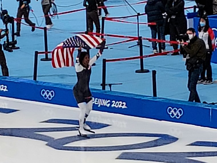 Speed skater Erin Jackson (USA) skates with the American flag after winning the gold medal in the 500m at the Beijing 2022 Winter Olympics.