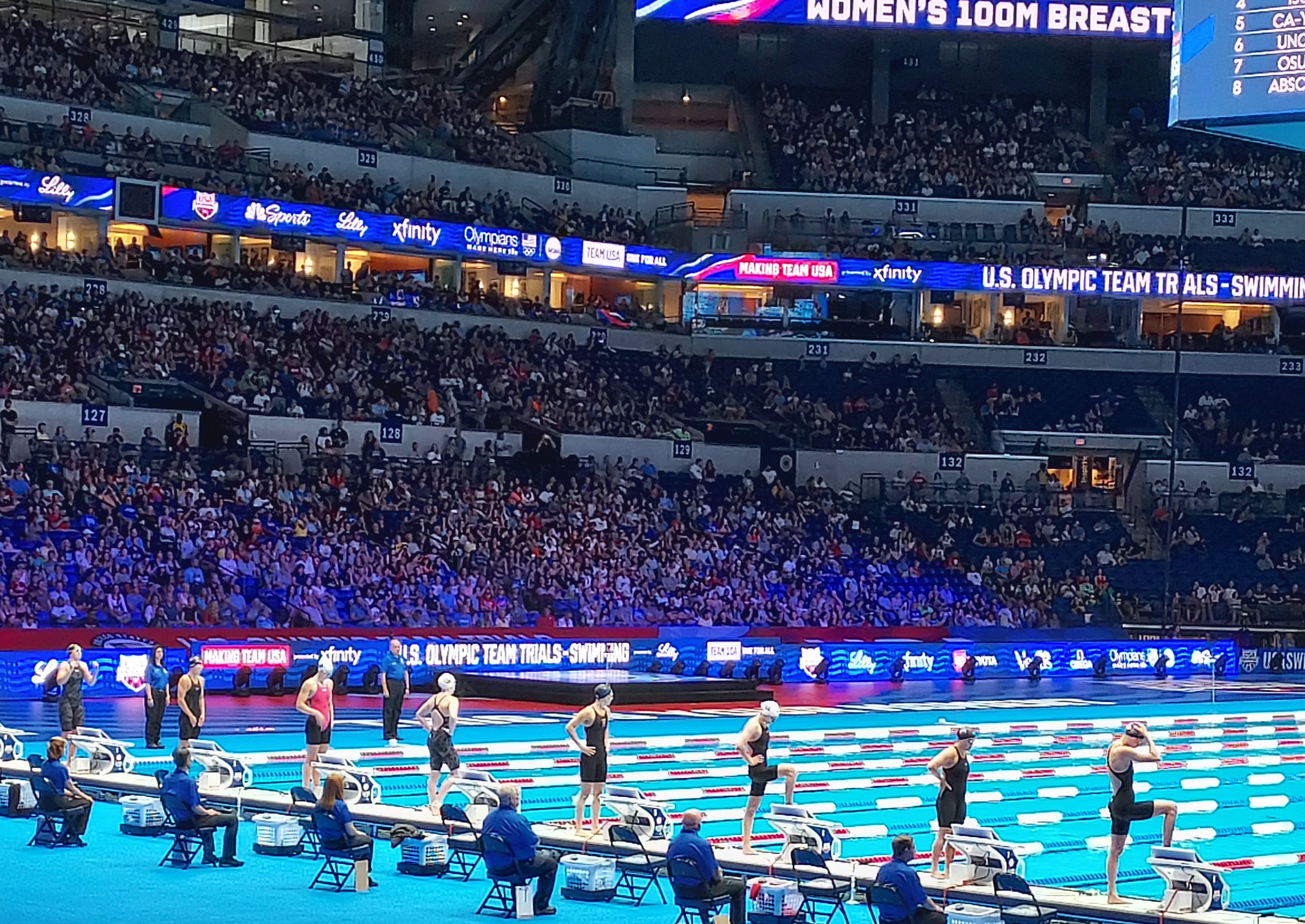 U.S. Olympic Swimming Trials at a packed Lucas Oil Stadium. Swimmers on deck ready to get on the starting blocks.