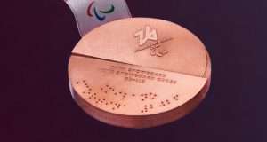 Paralympic medals for Milano-Cortina 2026 feature a divided circle, with the Games logo on one end, and the event in both English and Braille on the other.